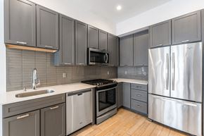 Jersey City apartment for rent - A modern kitchen with stainless steel appliances and wooden floors.