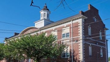 Lancaster apartment for rent - A red brick building with a white steeple and a clock on the side.