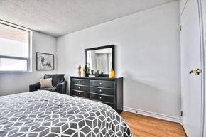 Ottawa apartment for rent - a bedroom with a bed and a dresser and a window