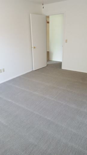 Normangee apartment for rent - an empty living room with a gray carpet and white walls