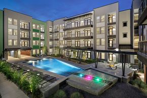 San Antonio apartment for rent - Resort-style courtyard pool with lounge seating, surrounding balconies, and evening lighting throughout the community