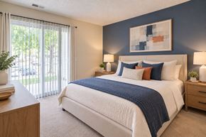 Baltimore apartment for rent - A bedroom with a large bed and a painting on the wall.