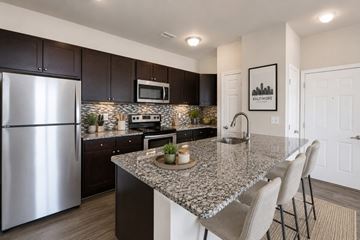 Baltimore apartment for rent - A kitchen with granite countertops and a stainless steel refrigerator.