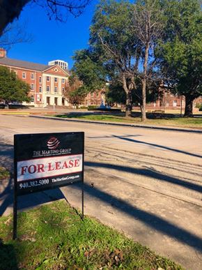 Denton house for rent - A Marting Group for lease sign is in the foreground of a parking lot.