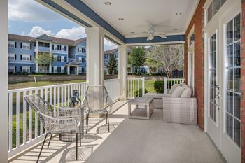 A balcony with a chair and table is shown