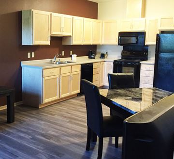 St. Cloud apartment for rent - A kitchen with a black refrigerator and a black dining table with four chairs.