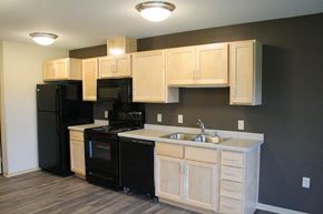 St. Cloud apartment for rent - A kitchen with black appliances and wooden cabinets.