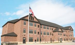 St. Cloud apartment for rent - A large brick building with an American flag on top.