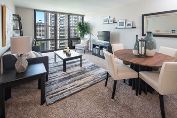 Living room layout with floor to ceiling windows, seating, and interior furnishings