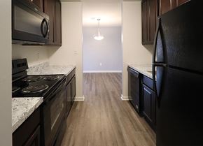 Camp Hill apartment for rent - an empty kitchen with black appliances and wood flooring