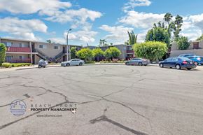 Brea apartment for rent - a parking lot in front of a building with cars parked