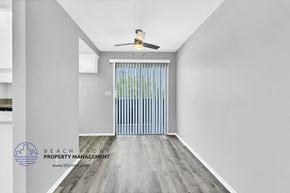 Brea apartment for rent - a living room with white walls and wood flooring and a door to a balcony