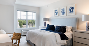 Amityville apartment for rent - A bedroom with a bed, chair, and pictures on the wall.