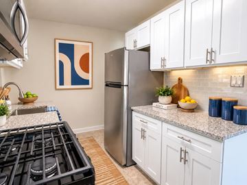 Alexandria apartment for rent - A modern kitchen with a stainless steel refrigerator and white cabinets.