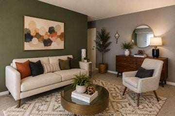 Alexandria apartment for rent - A living room with a white couch, a coffee table, a chair, and a painting on the wall.