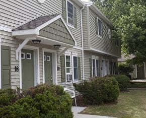 Albion apartment for rent - the front of a house with green doors and white siding