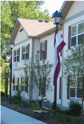 West Henrietta apartment for rent - a house with two flags and a bench in front of it
