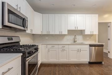 Chicago apartment for rent - a white kitchen with stainless steel appliances and white cabinets