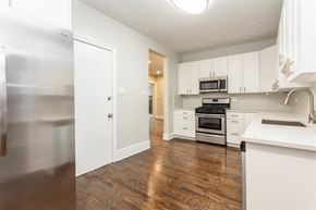 Chicago apartment for rent - an empty kitchen with white cabinets and stainless steel appliances