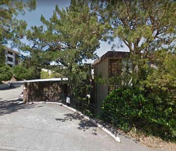 Greenbrae apartment for rent - A small building is surrounded by a fence and trees.