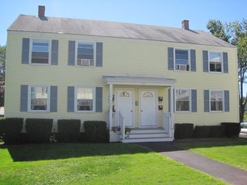 South Portland apartment for rent - A yellow house with a white door and windows.