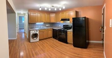 South Portland apartment for rent - A kitchen with wooden cabinets and black appliances.