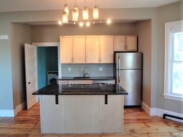 Portland apartment for rent - A kitchen with a black counter top and white cabinets.