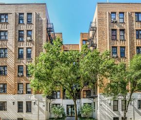 Manhattan apartment for rent - a view of two brick apartment buildings with trees in the middle