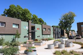 Lakewood apartment for rent - A modern apartment complex with a courtyard and a car parked in front.