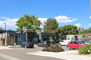 Lakewood apartment for rent - A parking lot with cars and a building named Belmar Groves.