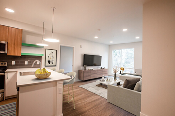Lakewood apartment for rent - A modern kitchen with a white countertop and a white couch in the living room.