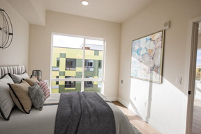 Lakewood apartment for rent - A bedroom with a large bed and a painting on the wall.