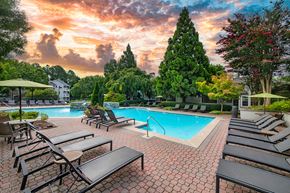 Atlanta apartment for rent - a swimming pool with chairs and umbrellas at sunset