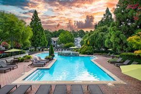 Atlanta apartment for rent - a swimming pool with chairs and umbrellas at sunset