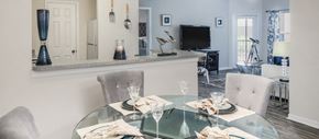 Tampa apartment for rent - a dining room with a glass table and chairs and a kitchen with a television