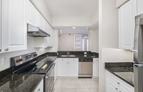 Tampa apartment for rent - a kitchen with granite counter tops and white cabinets