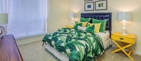 Tampa apartment for rent - a bedroom with a bed with green and yellow pillows