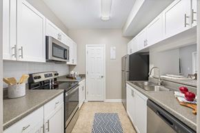 Centreville apartment for rent - A kitchen with white cabinets and a black refrigerator.