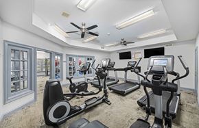 Charlotte apartment for rent - A spacious gym with treadmills, elliptical machines, and a fan.