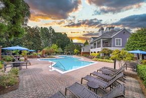 Charlotte apartment for rent - a swimming pool with benches and a house in the background