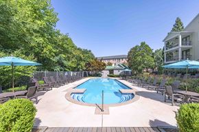 Atlanta apartment for rent - A large outdoor pool surrounded by lounge chairs and umbrellas.