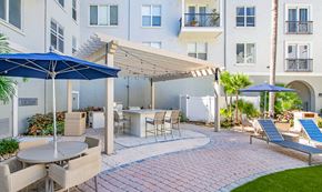 Tampa apartment for rent - a patio with tables and chairs and umbrellas in front of a building