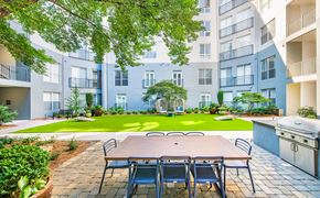 Atlanta apartment for rent - an outdoor dining area with a table and chairs in front of an apartment building