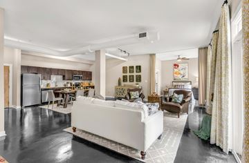 Atlanta apartment for rent - A modern living room with a white sofa and a kitchen in the background.