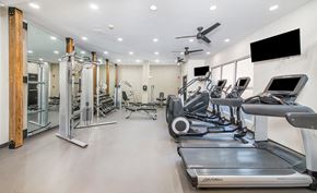 Atlanta apartment for rent - a gym with cardio equipment and a flat screen tv