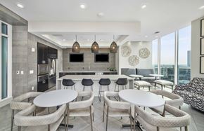 Atlanta apartment for rent - a communal area with tables and chairs and a kitchen and television