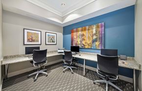 Rockville apartment for rent - a conference room with four desks and chairs and a wall with artwork