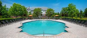 Charlotte apartment for rent - a swimming pool with chairs around it and a house in the background