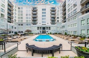 Charlotte apartment for rent - a swimming pool with lounge chairs in front of an apartment building