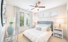 Raleigh apartment for rent - a bedroom with a large bed and a ceiling fan